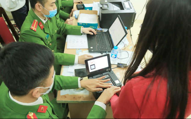 Cán bộ công an lấy dấu vân tay làm thủ tục cấp căn cước công dân gắn chíp và tài khoản định danh điện tử cho người dân. Ảnh: SKĐS.